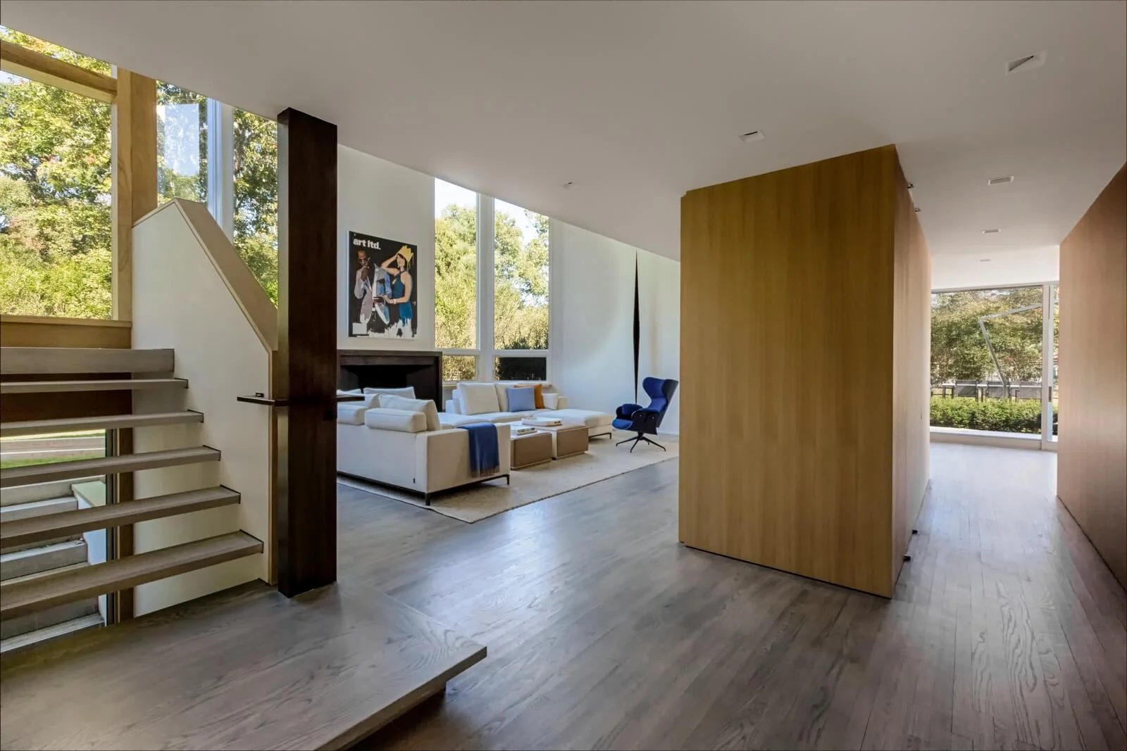 Luxury whole-home renovation by Grandeur Hills Group — open-plan Hamptons living room with architectural staircase and white-oak floors